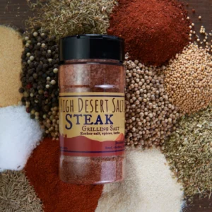 A jar of steak seasoning on top of many different spices.