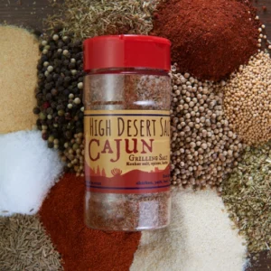 A jar of cajun seasoning on the ground.