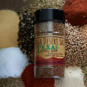 A jar of spices on top of a pile of other different types of food.